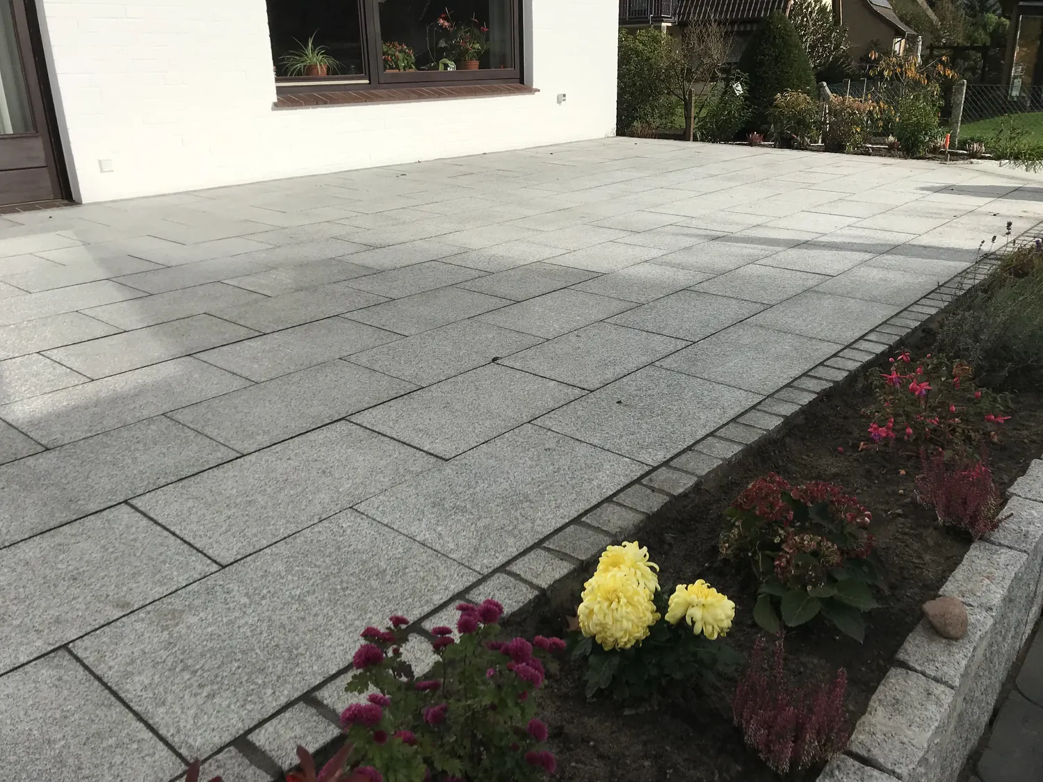 Granitplatten-Terrasse mit angrenzendem Staudenbeet